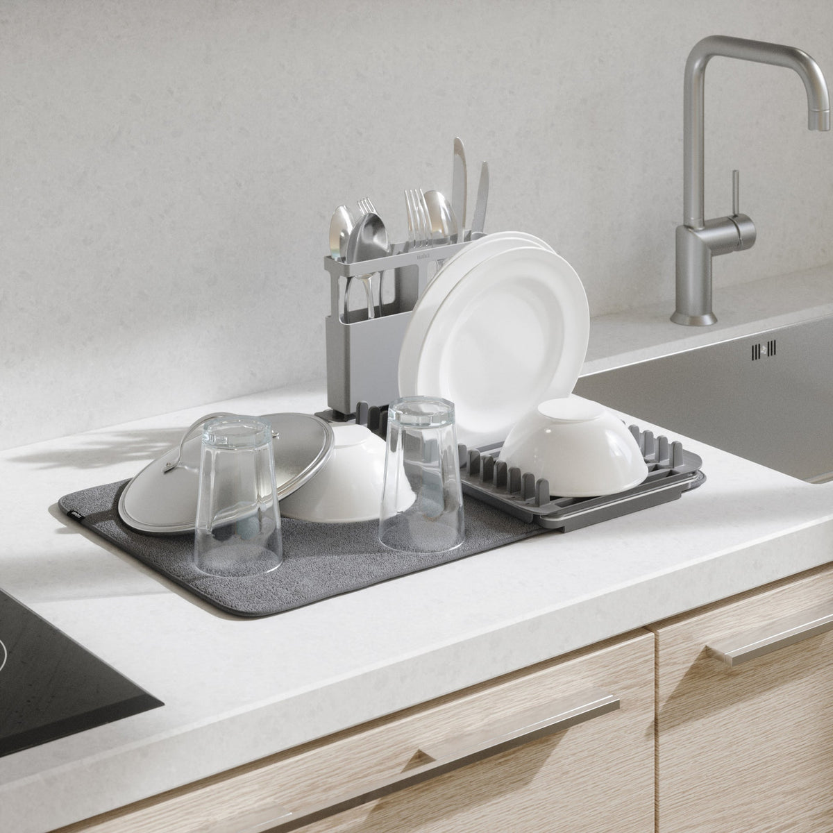 Umbra Udry dish rack over the sink with plates, glasses and cutlery drying on the mat
