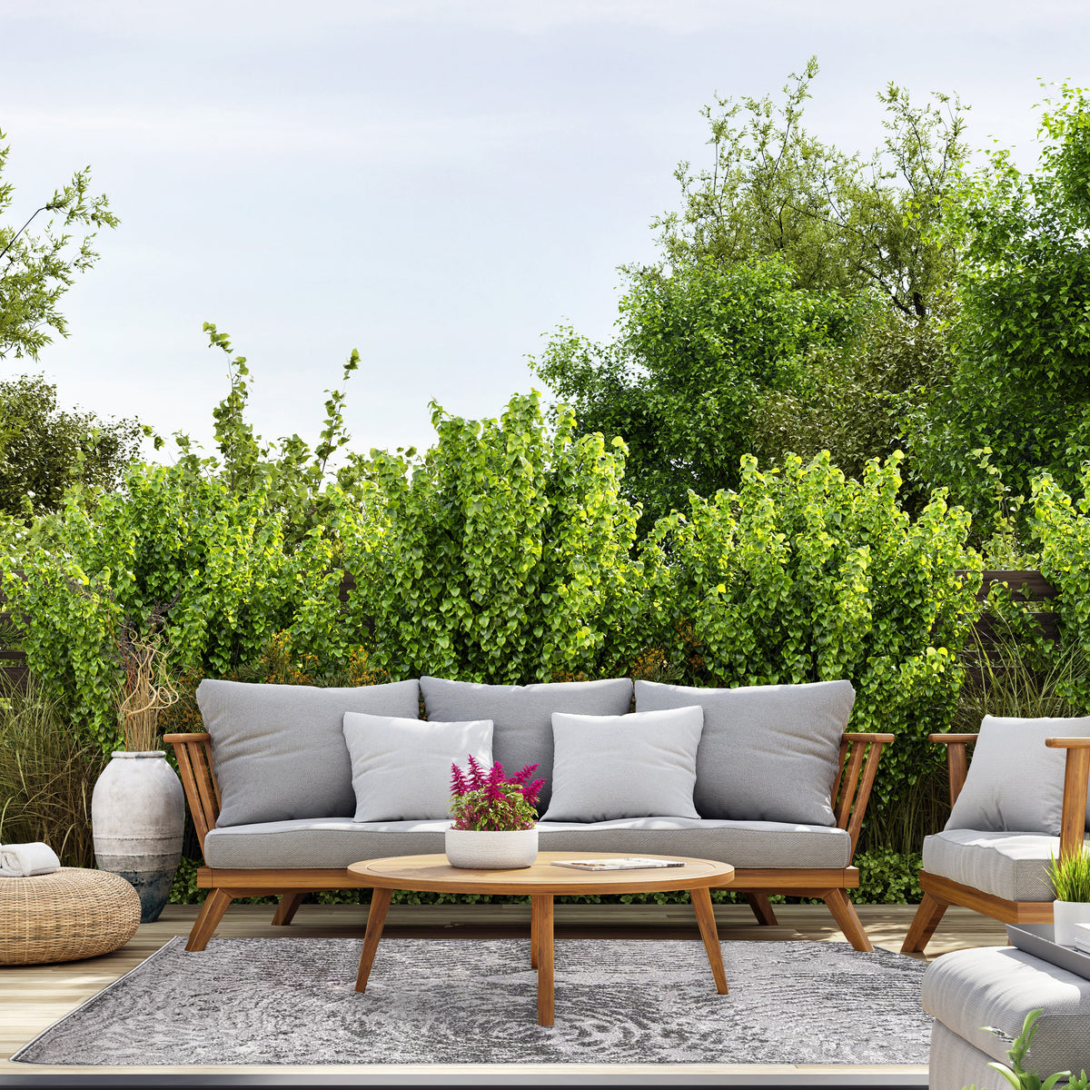 Dark grey rug on an outdoor deck under a timber sofa with grey cushions and a round coffee table