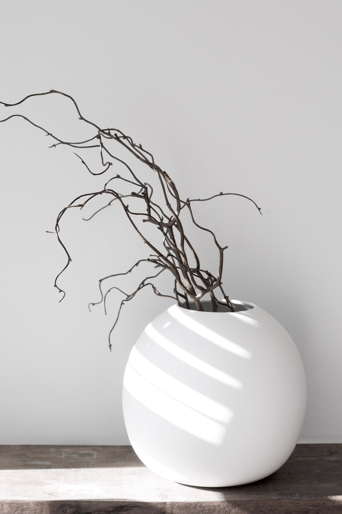 Harmie organic ceramic vase in white styled with sculptural branches on wooden console