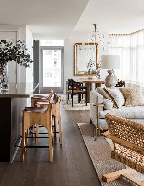 Interior from At Home: timber and leather bar stools beside a sitting room with a gilt mirror