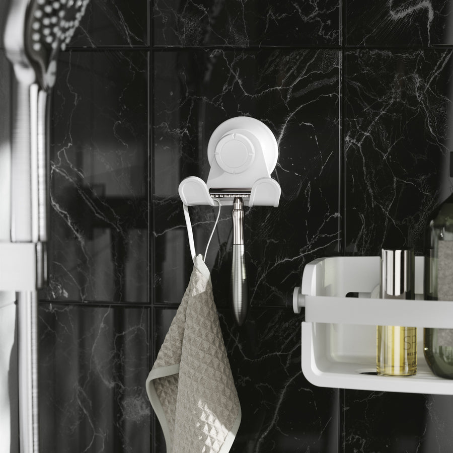 Umbra Flex adhesive double hook in white holding a cloth on black marble tiles