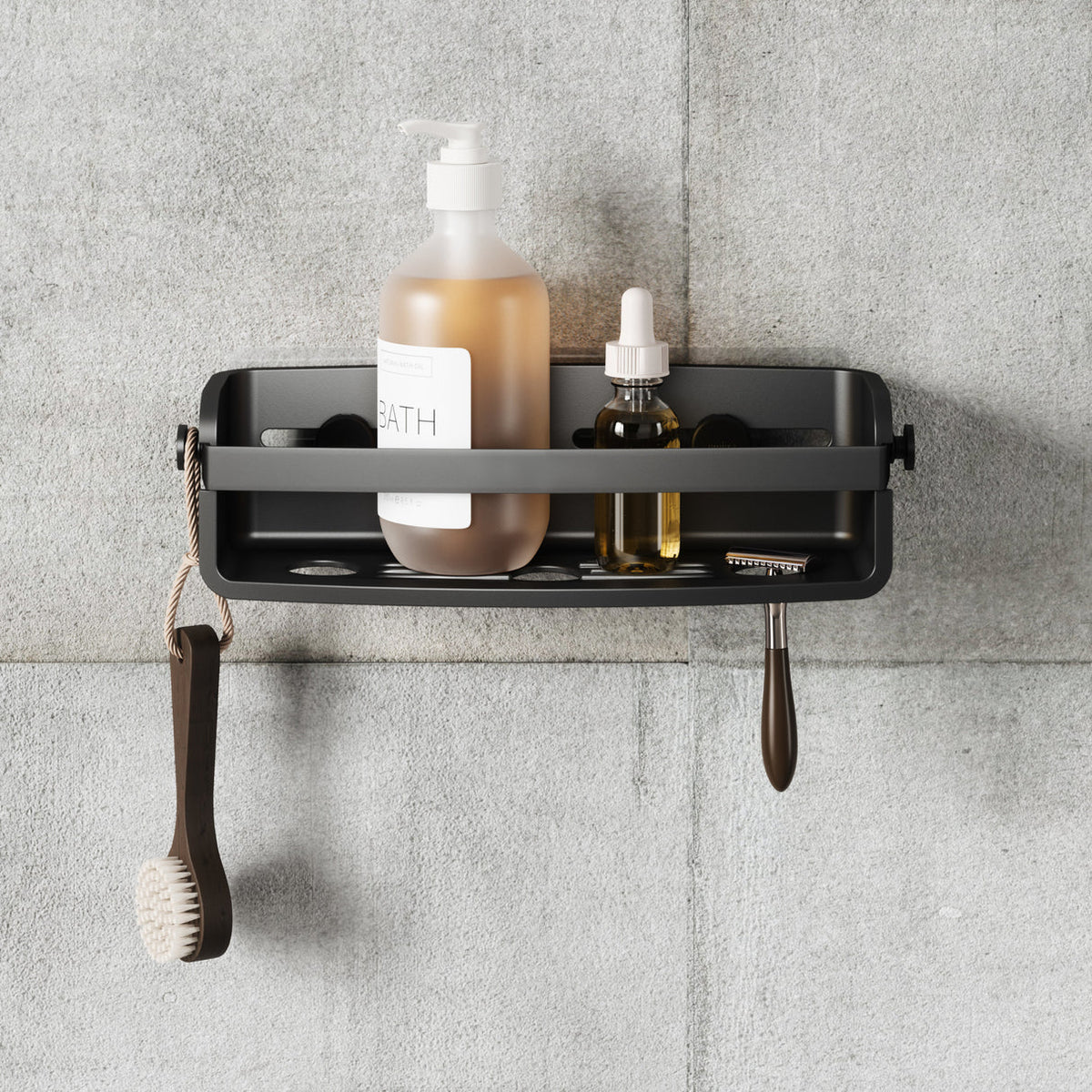 Umbra Flex shower bin in black on grey tiles holding a soap pump and dropper bottle