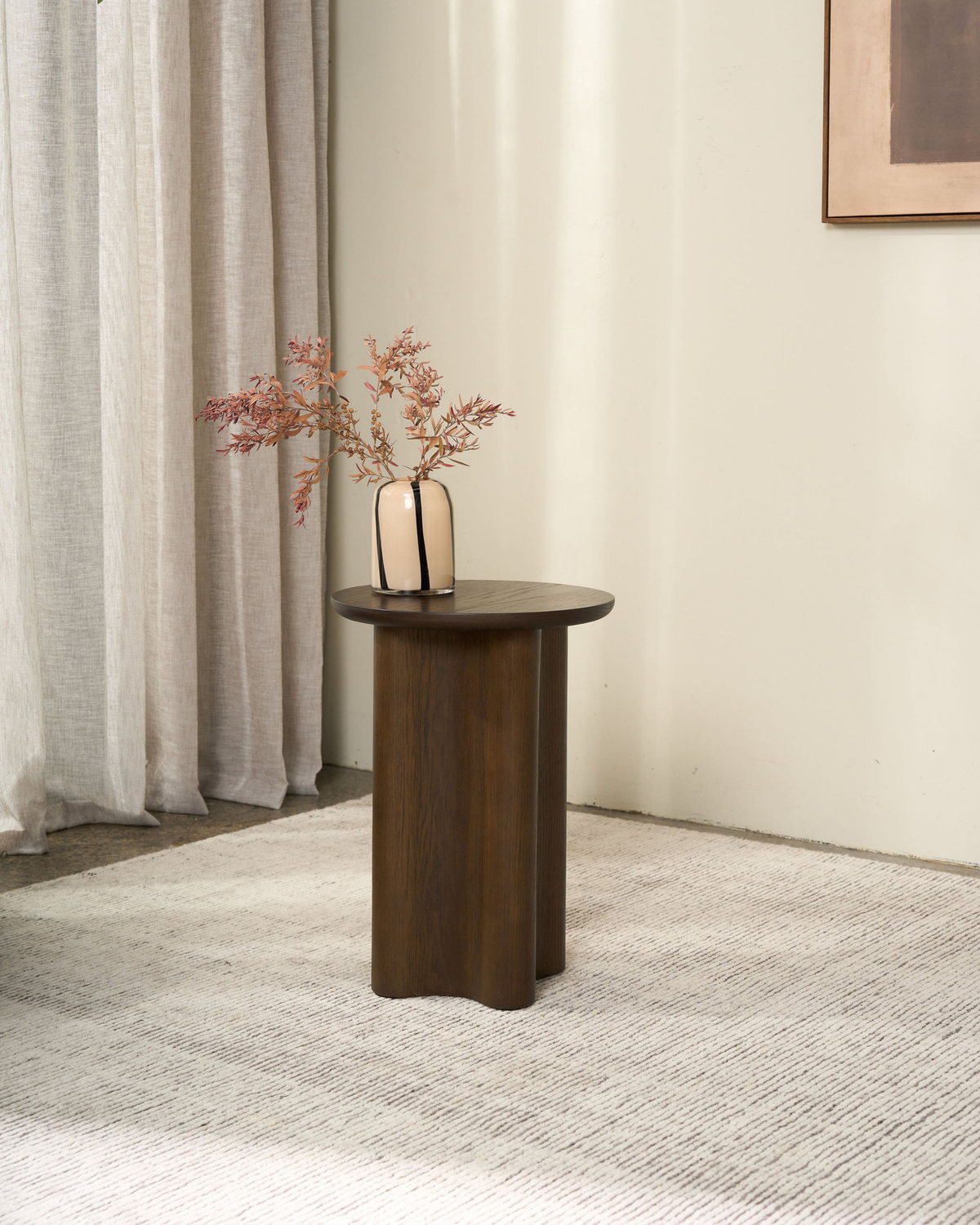 Brown Oak Luma Side Table holding a cream striped glass vase of dried pink stems