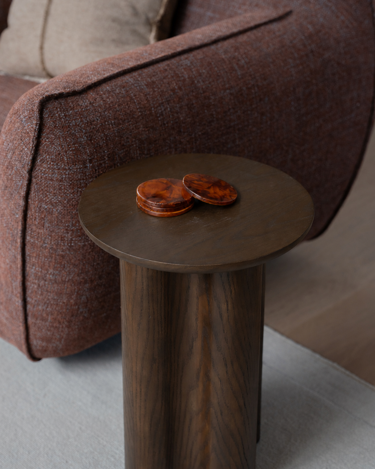Close view of the Luma Side Table oak grain in Brown Oak with tortoiseshell coasters on top