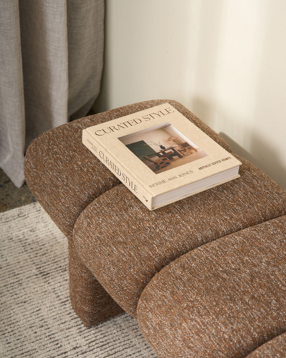 Close view of the flecked channel padding with the book Curated Style resting on the seat