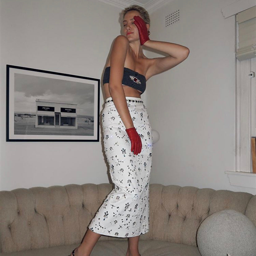 Woman posing in front of the Marfa print in a black frame above a tufted sofa