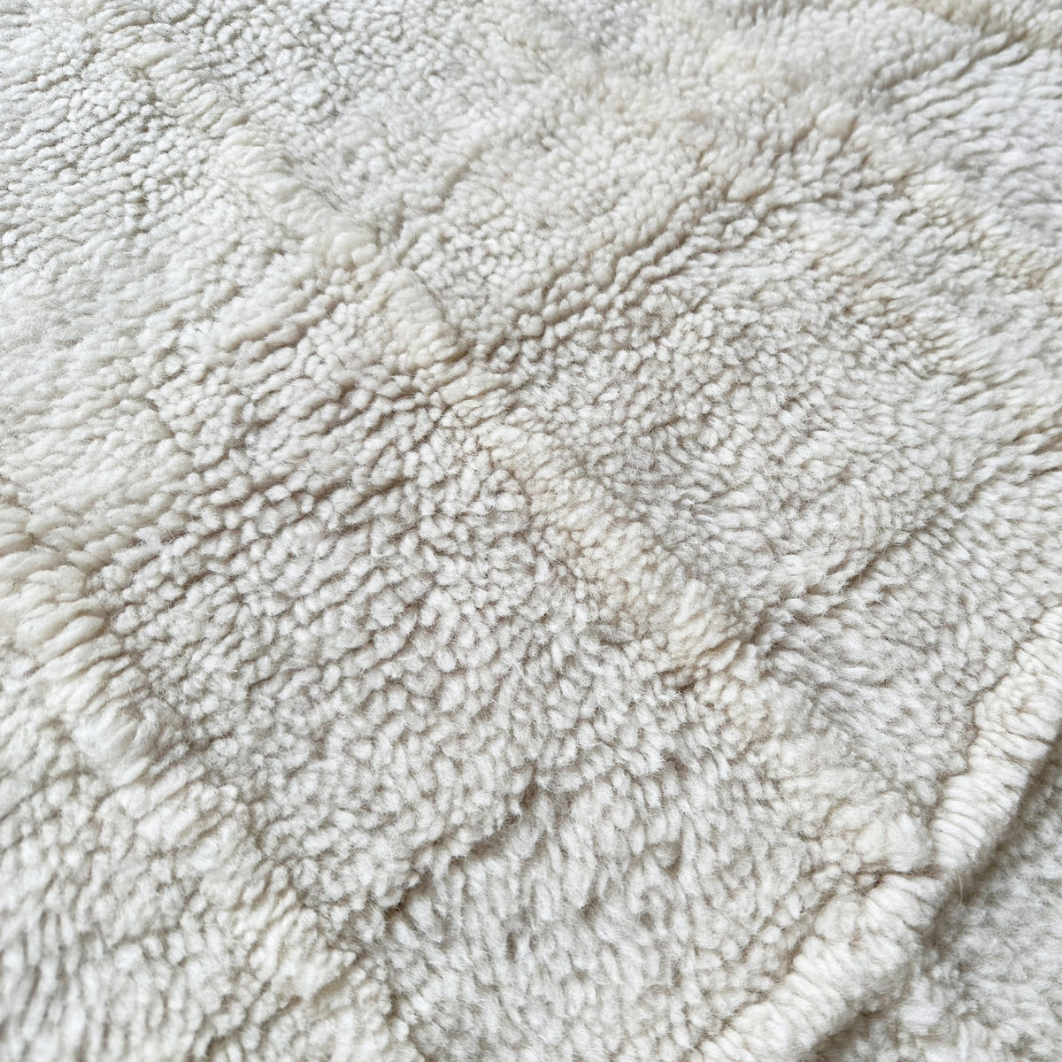 Close view of the raised diamond lattice in the ivory wool pile