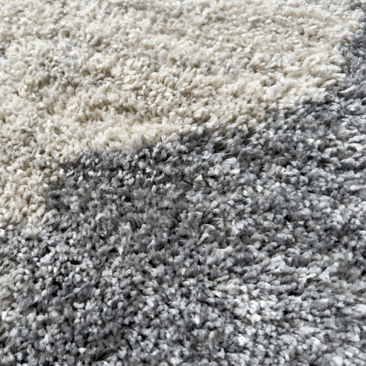 Close view of the plush grey and ivory pile where two bands meet