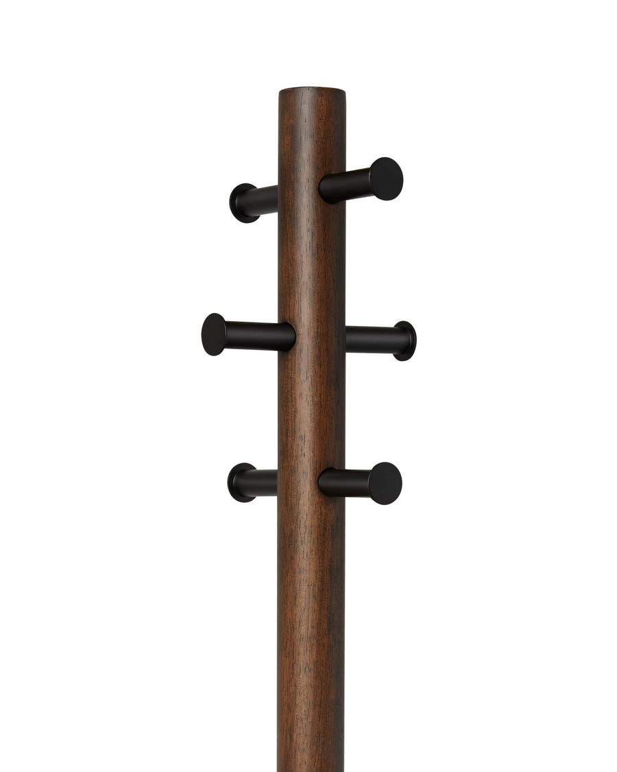 Close-up of the six black peg hooks on the walnut Umbra Pillar coat rack