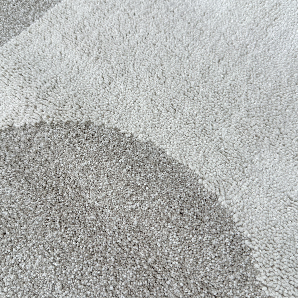 Close view of a raised beige curve in the ivory high-low pile