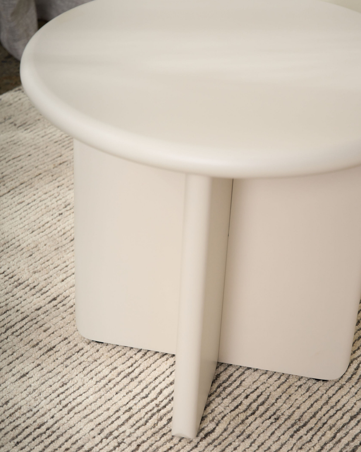 Close view of the rounded top edge and the flat fins of the cross base in Cream