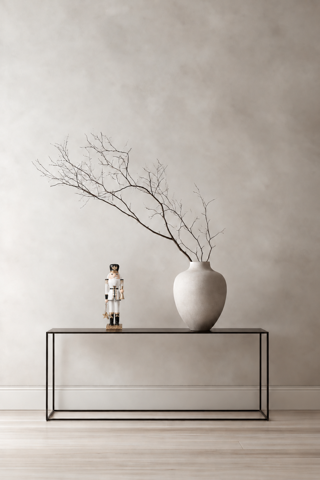 Nutcracker Soldier Holding Star and Trumpet 21cm on a slim black console beside a stone vase of bare branches