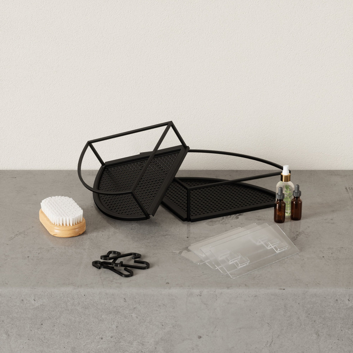 Umbra Cubiko corner bins in black beside their waterproof adhesive strips