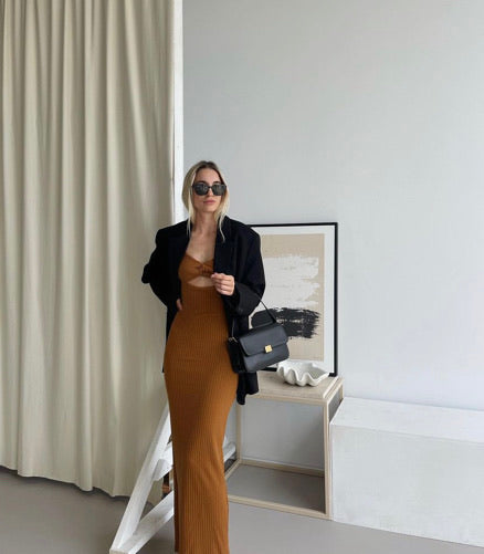 Woman in a long dress standing beside the Painted Canvas print in a black frame