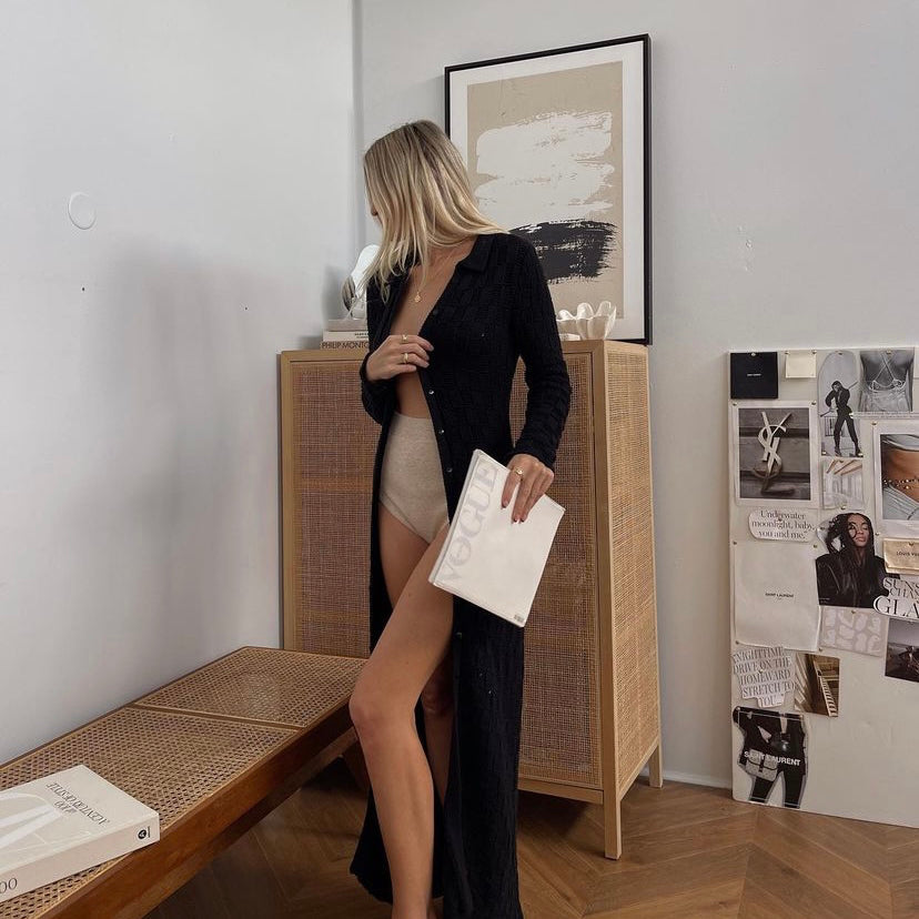 Woman holding a book beside the Painted Canvas print framed above a rattan cabinet