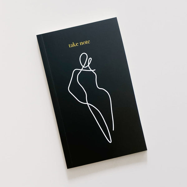 A stylish black HOMEBODII notebook with a line drawing of a woman, perfect as a gift for stationery lovers. Brand name: Papier HQ.