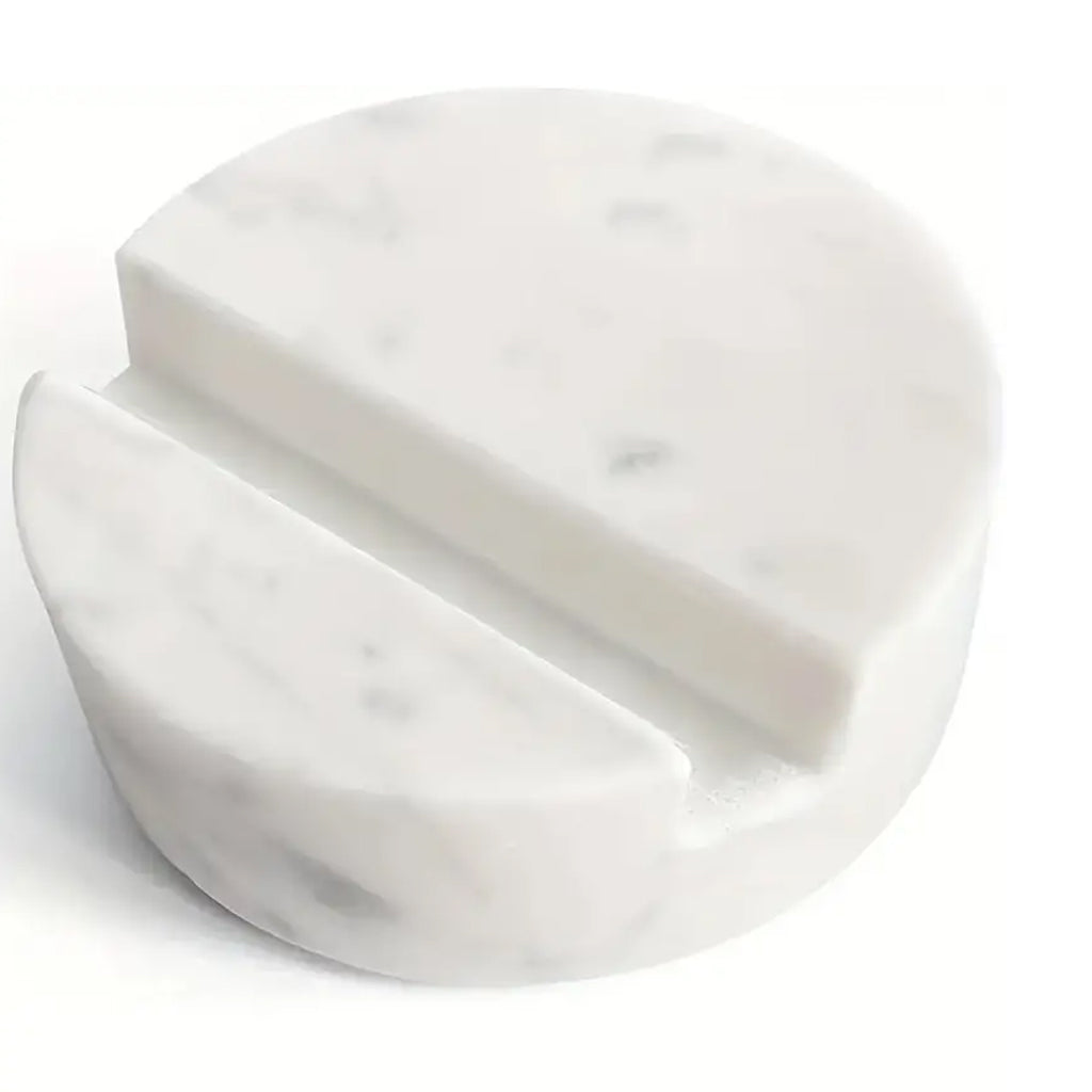 Close-up of the white marble phone stand showing its angled groove