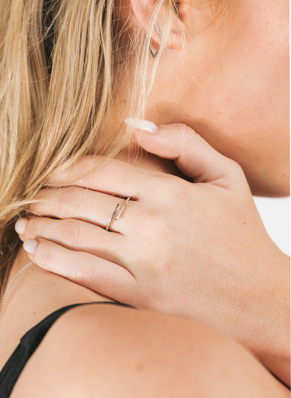 Hand at the neck wearing the Pipe Ring, model's hair falling over her shoulder