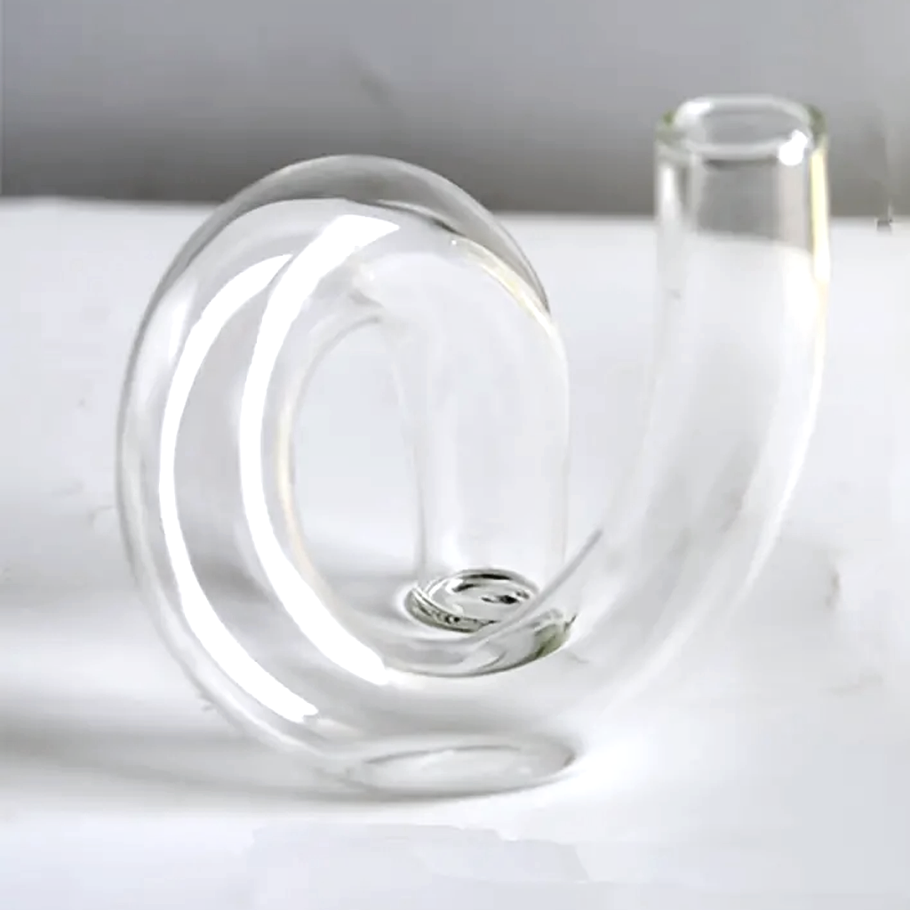 Clear J-Curve vase close up on a white surface against a soft grey backdrop