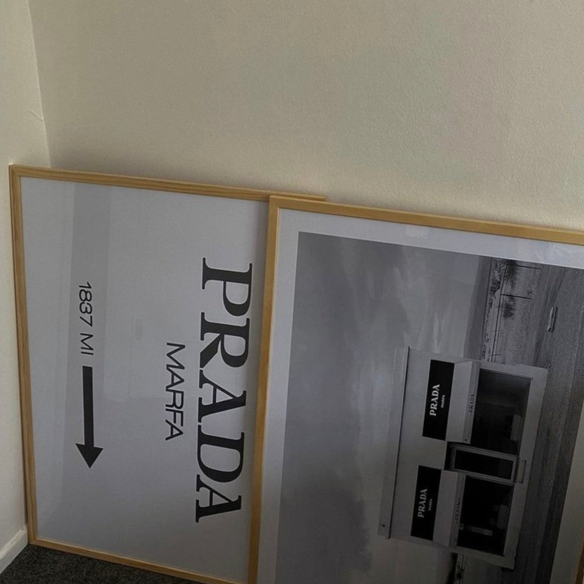 Prada Marfa print in a natural frame leaning beside the Marfa print