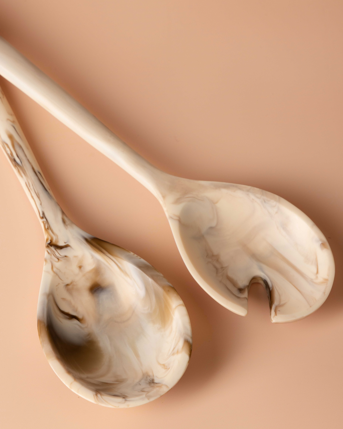 Close view of the Tiramisu spoon and notched server heads with caramel swirls through cream resin