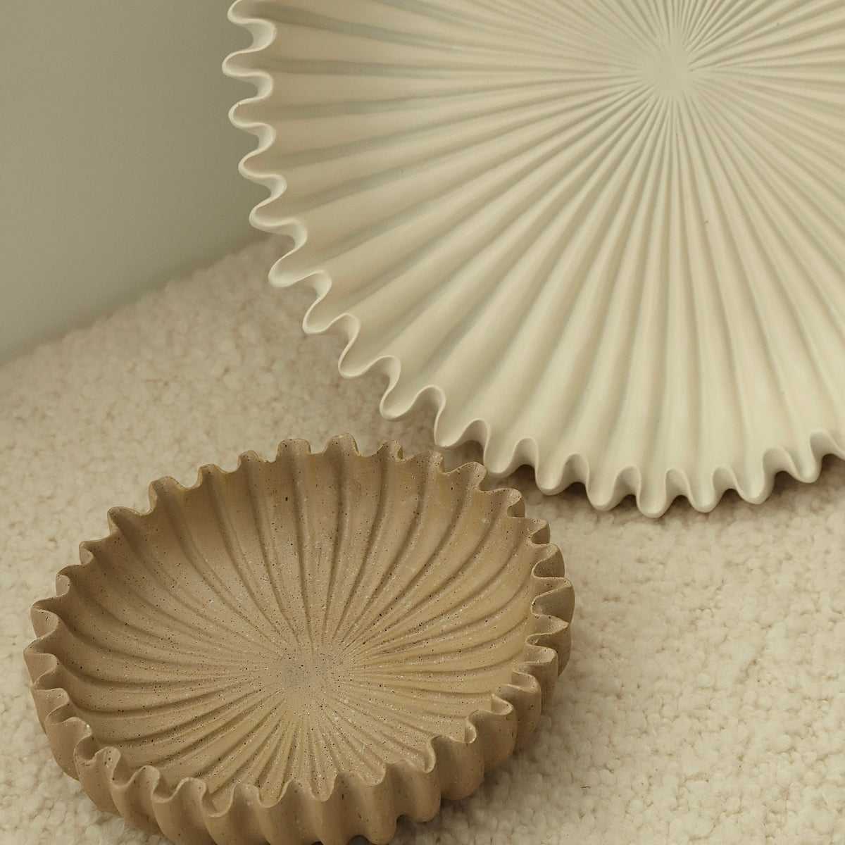 Close view of the scalloped ridges of the Rome platter on a cream surface