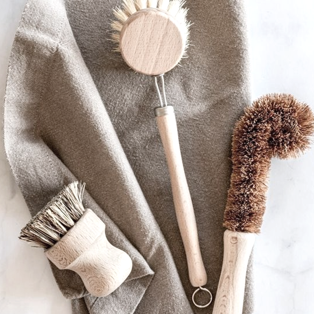 Pot brush with a long-handled dish brush on a linen tea towel