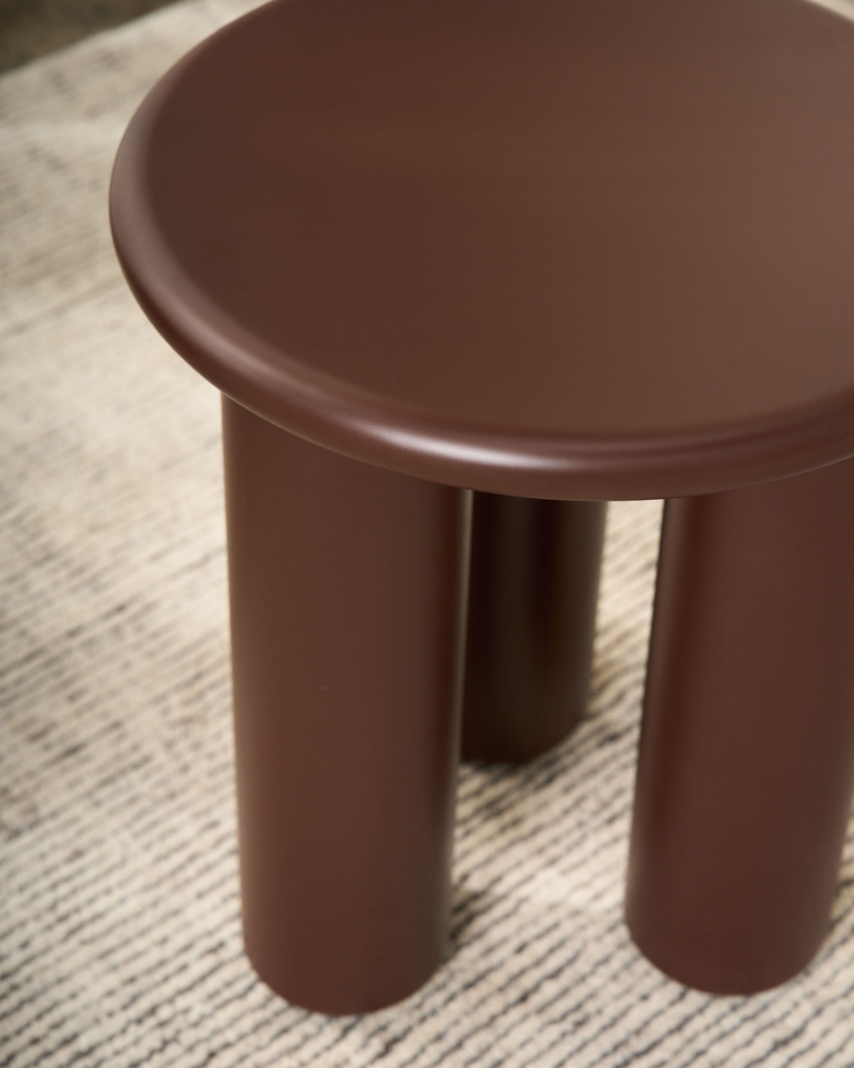 Close view of the rolled edge top and rounded legs in Rouge matt lacquer