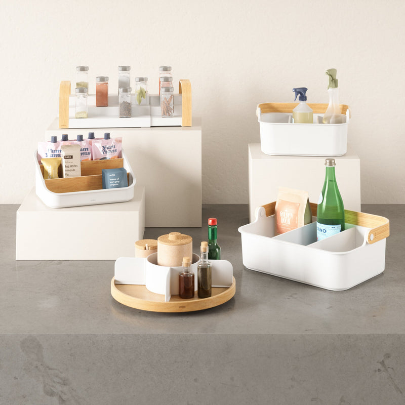 A stackable Bellwood Storage Bin by Umbra for organizing bottles and other items, promoting sustainable practices.