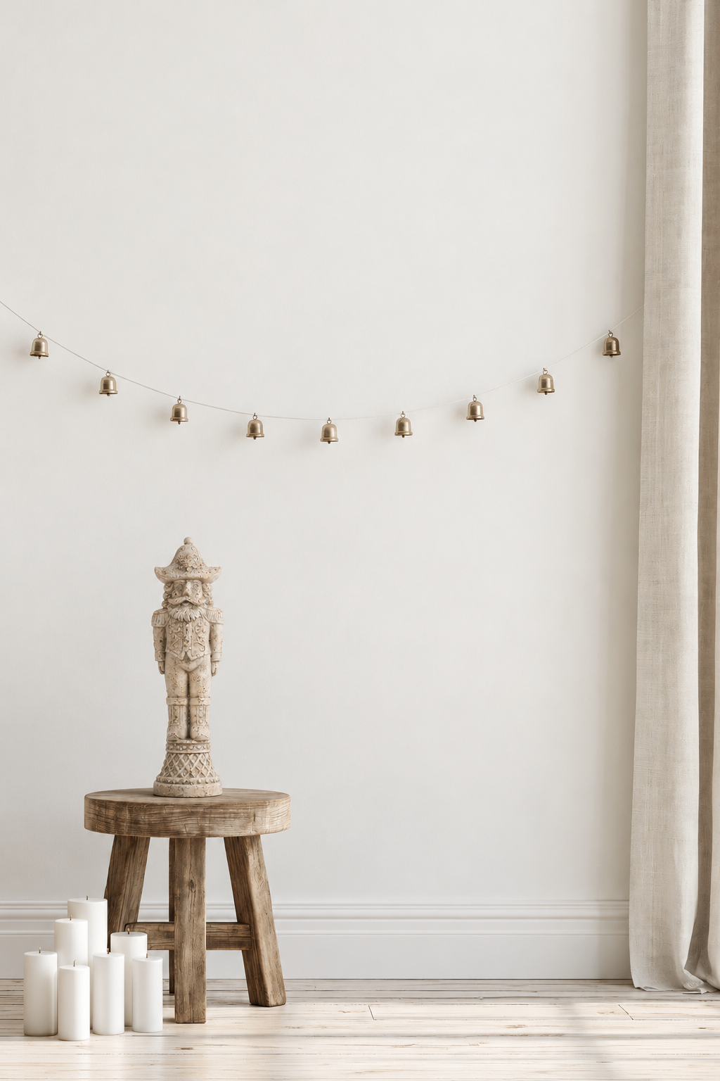 Stone-look nutcracker soldier 39cm on a timber stool beside pillar candles under a brass bell garland