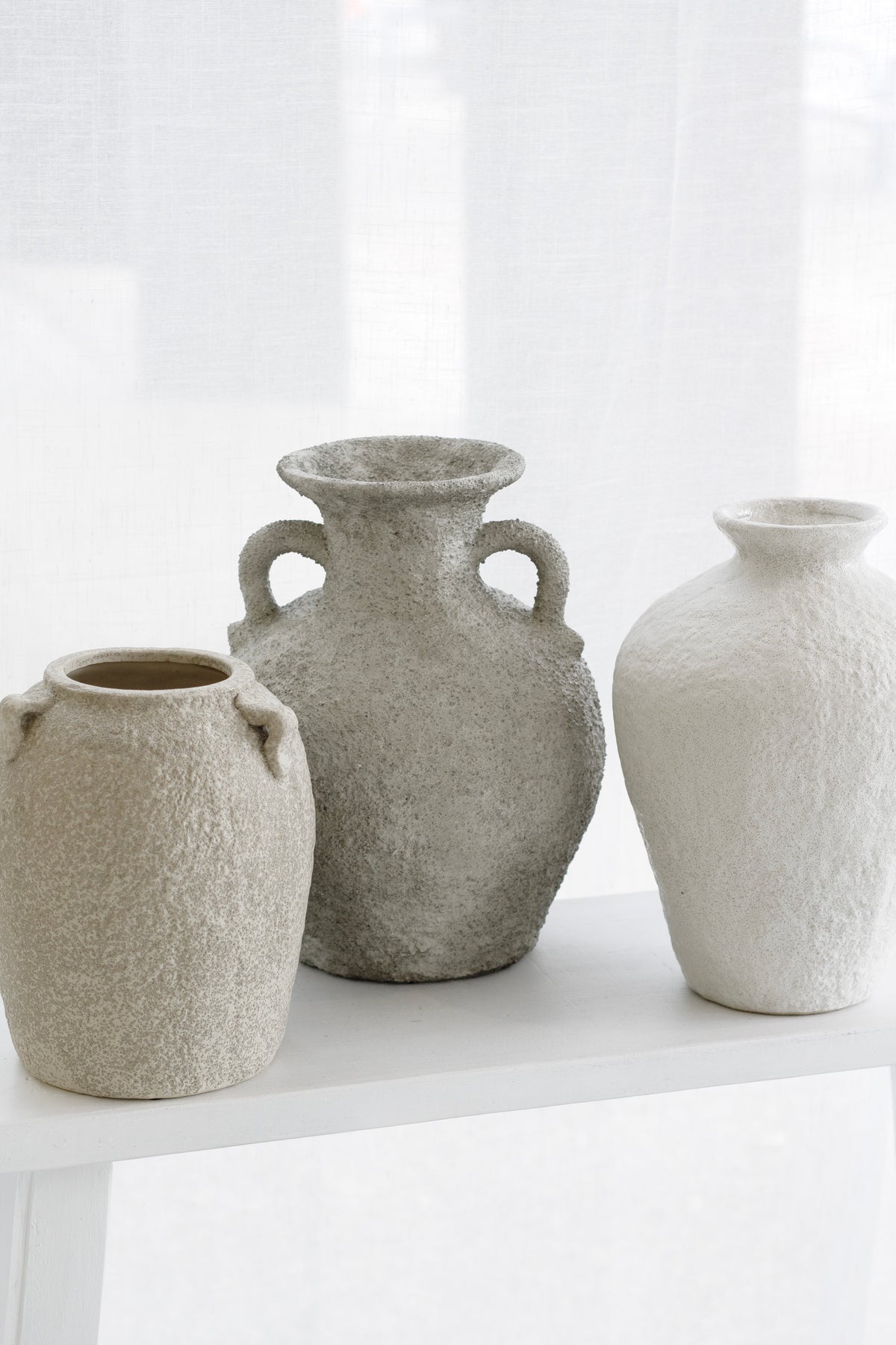 Thira Vase displayed with other vases in tonal grey and white palette