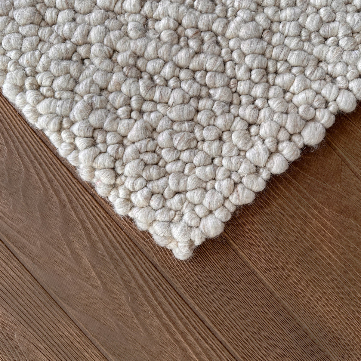 Corner of the sand pebble loop rug on a timber floor