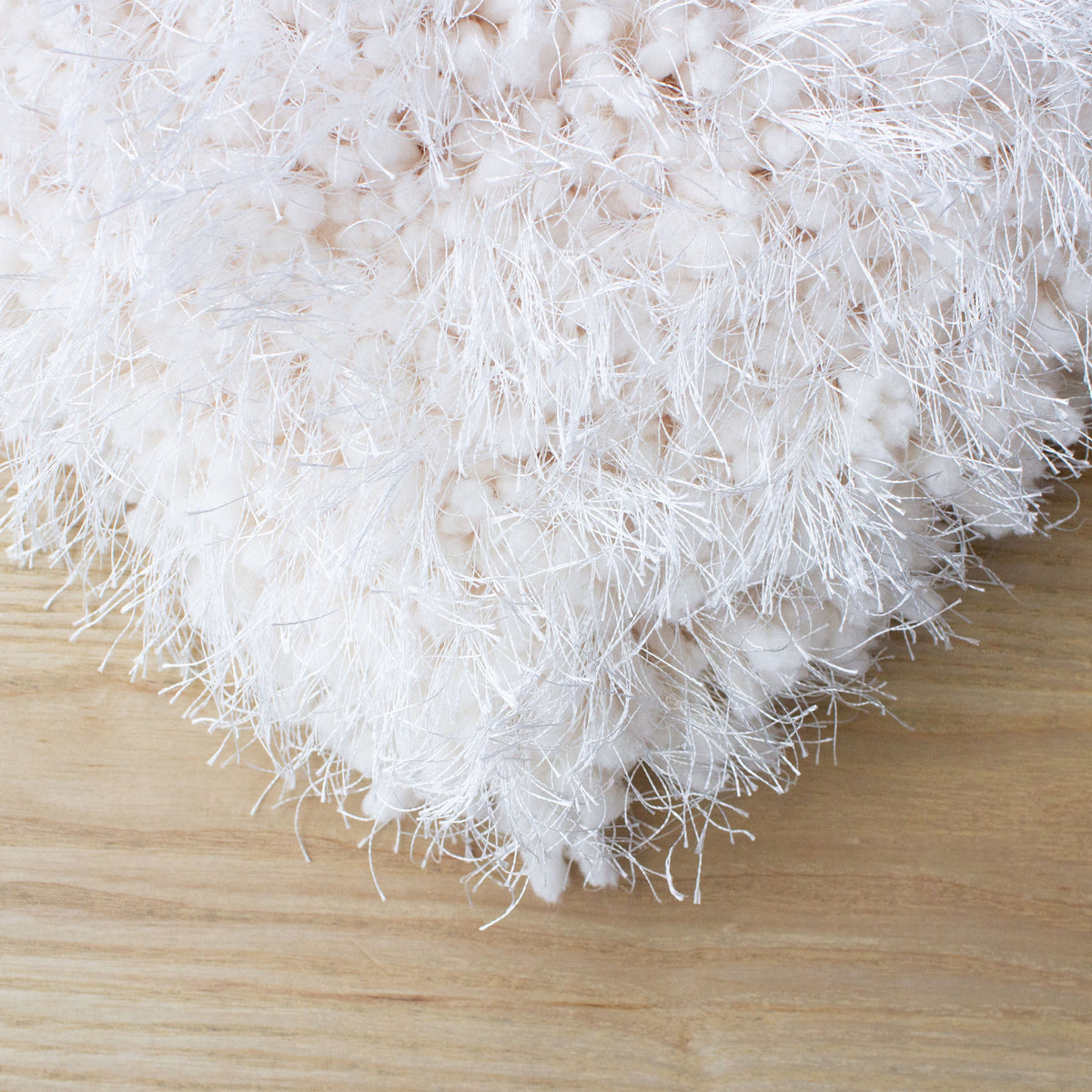 Corner of the white shag rug on a pale timber floor