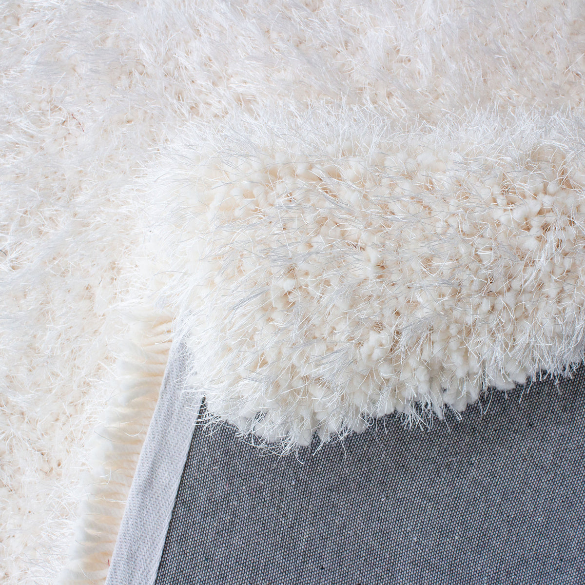 Close view of the long, fine strands of the white shag pile