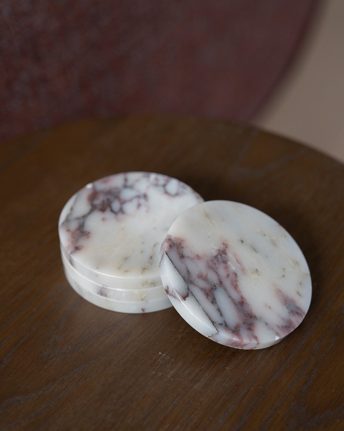 Viola Marble coasters on a dark timber table, three stacked with one leaning against them