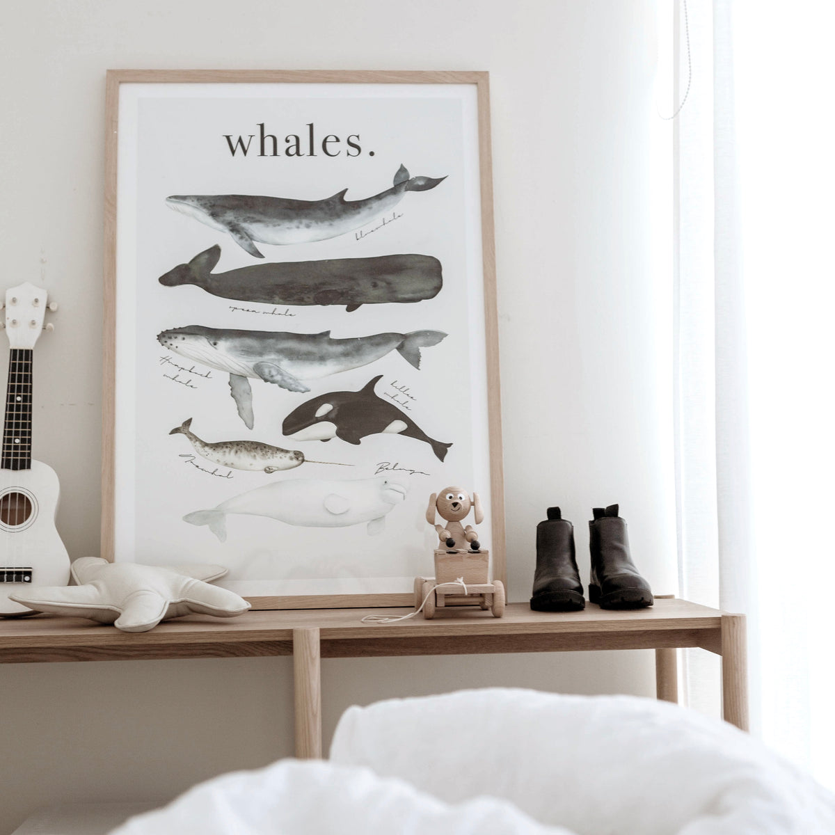 Watercolour Whales print in a natural frame on a timber bench with small leather boots
