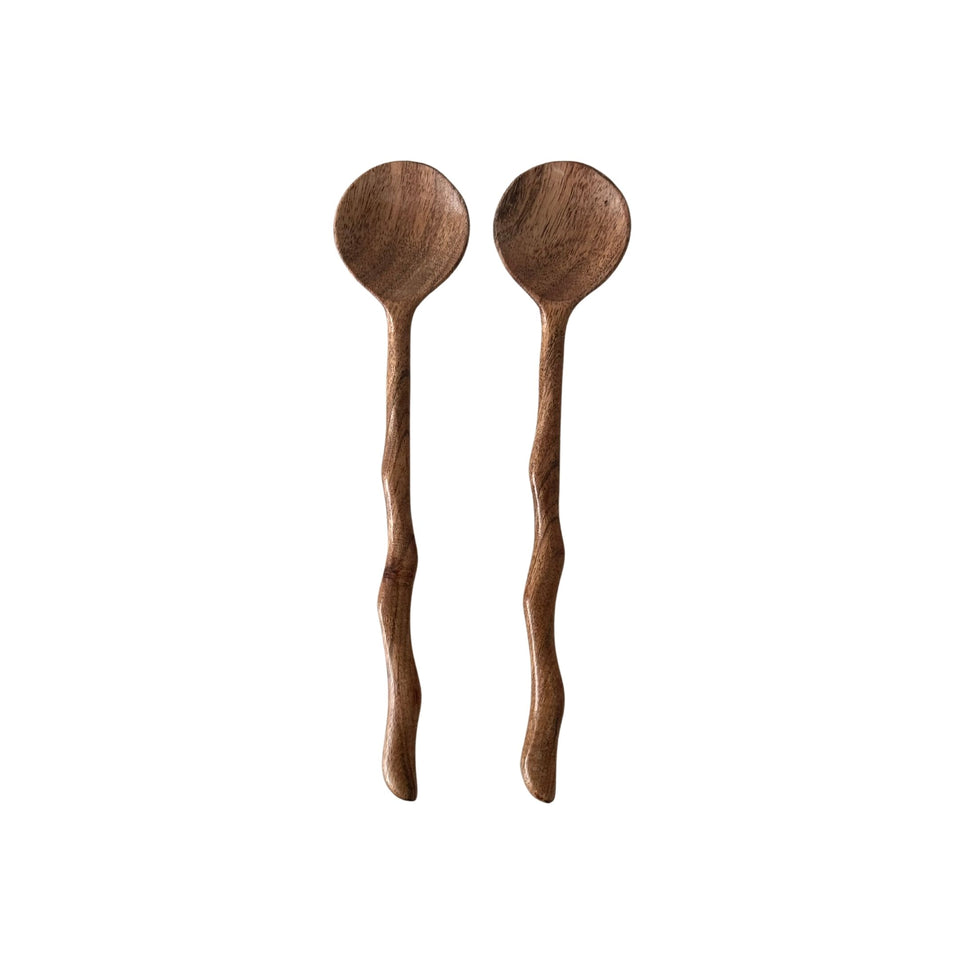 Hand-carved wooden salad servers styled in a ceramic bowl