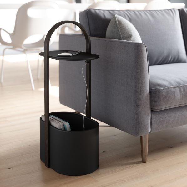 Umbra Bellwood storage table in black beside a grey sofa, magazines stored in the base bin