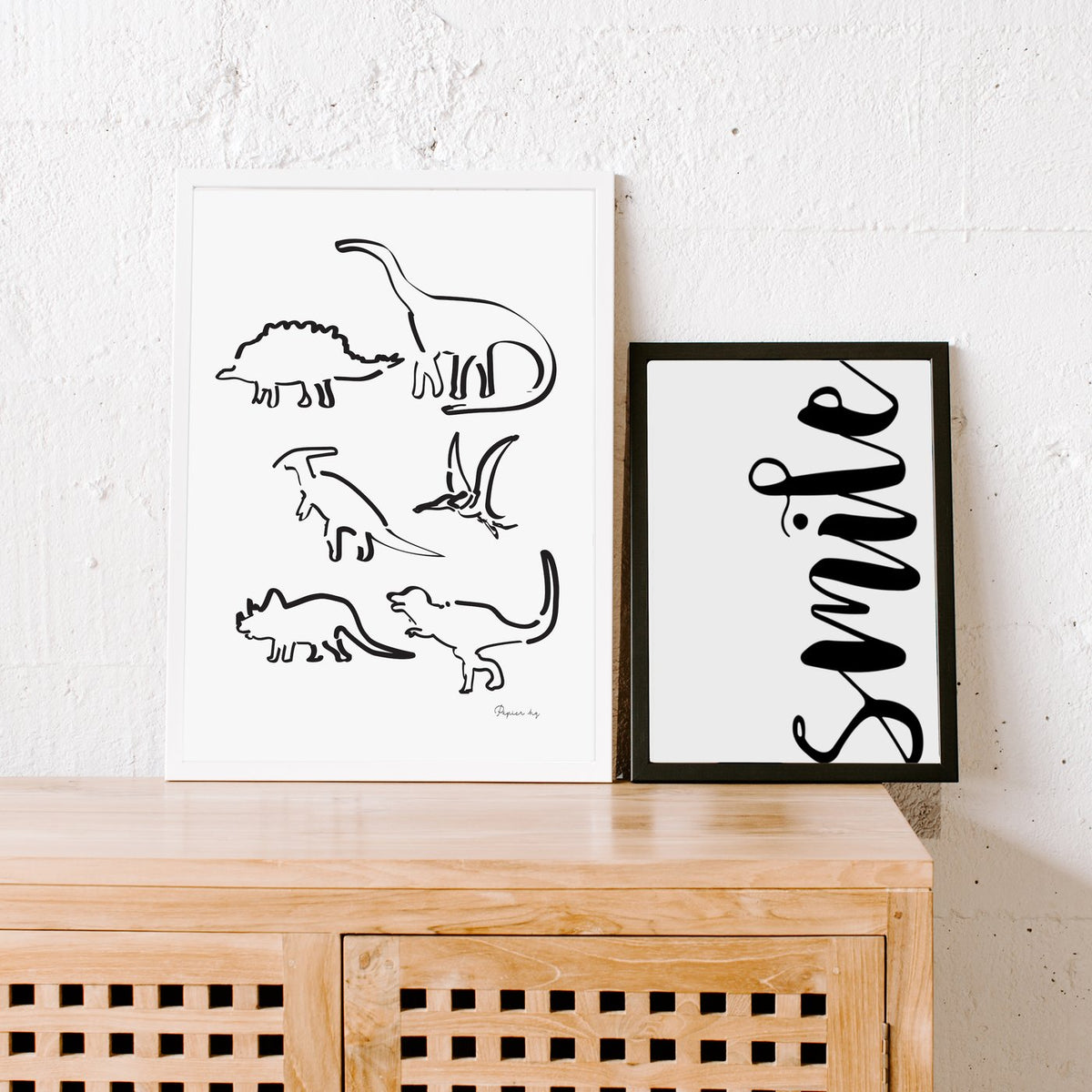 Dinosaur print beside a smile script print on a timber cabinet