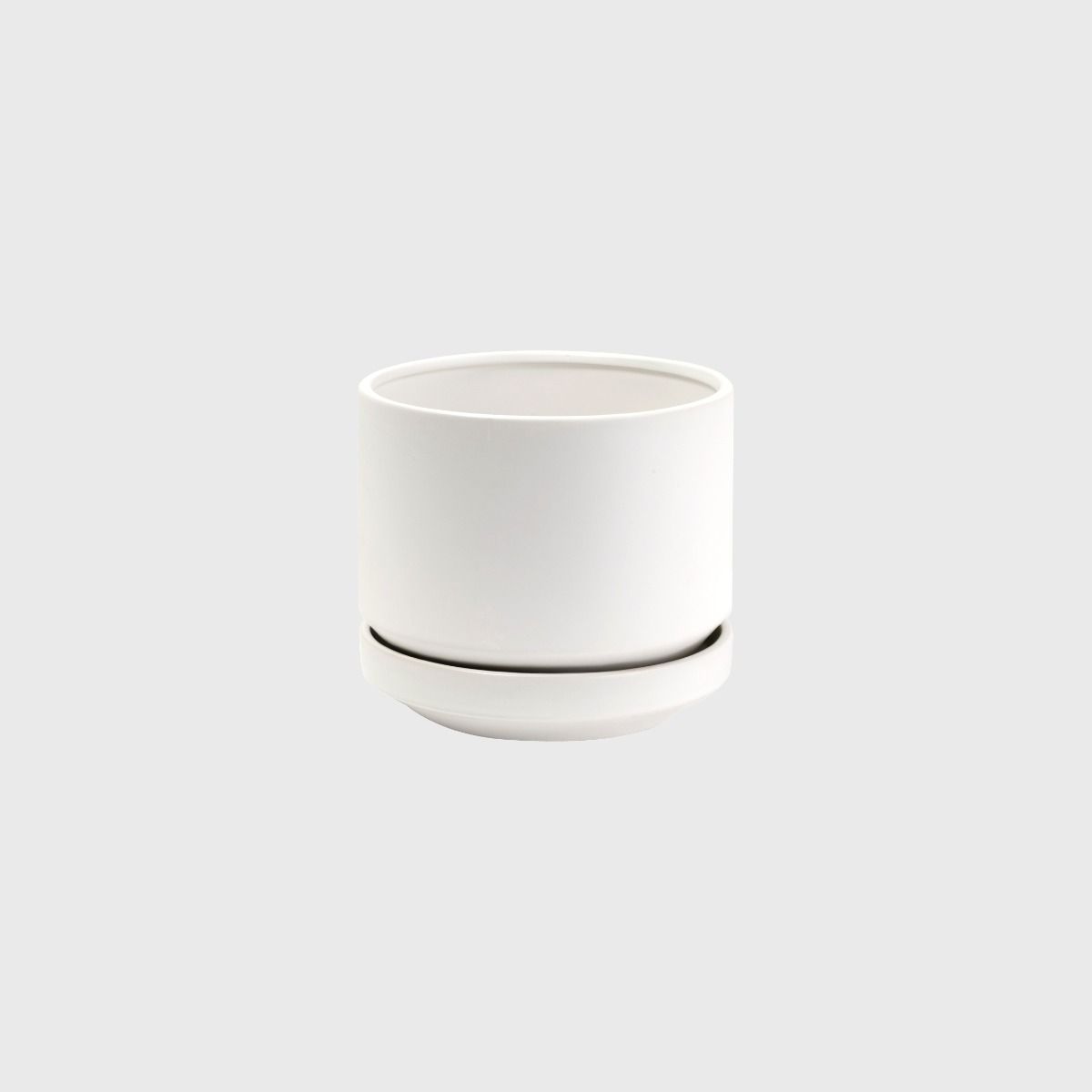 Small white Zurich ceramic planter with saucer on a grey background