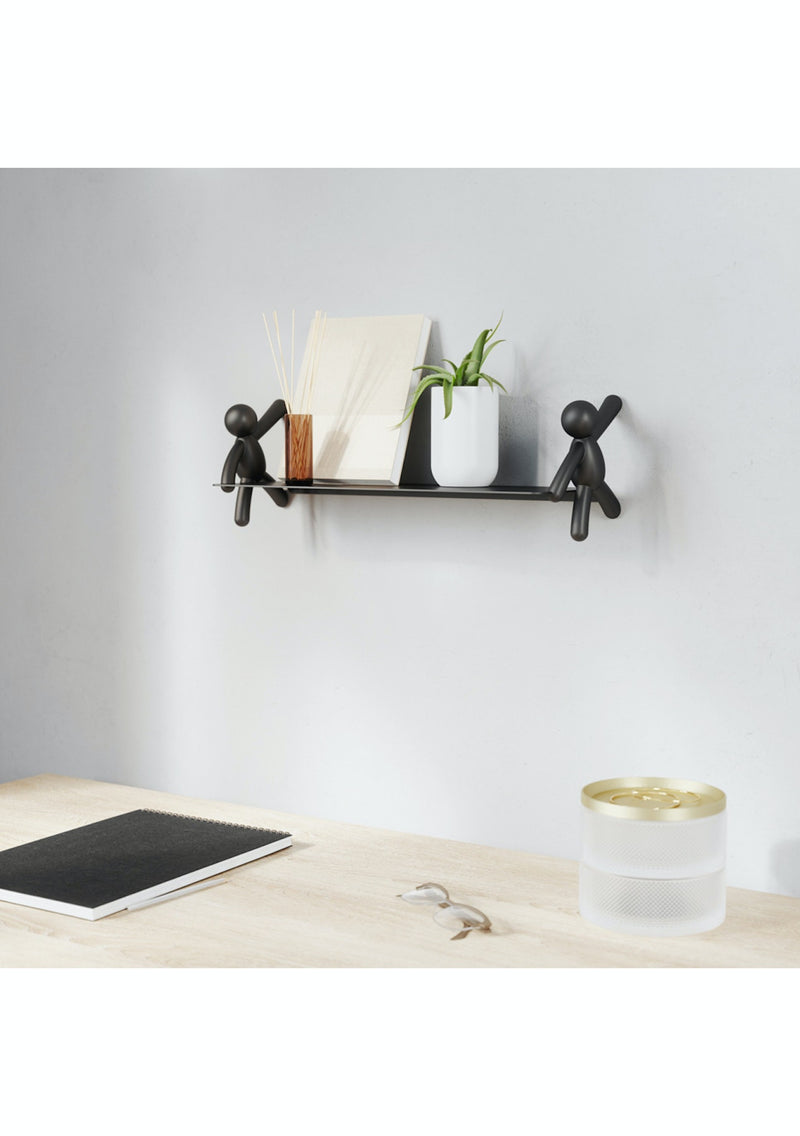 A decorative Buddy Shelf - Black / White by Umbra with a tablet and a plant on it.