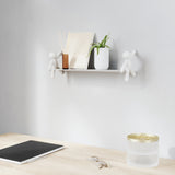 A wooden desk with a Umbra Buddy Shelf - Black / White and a laptop.