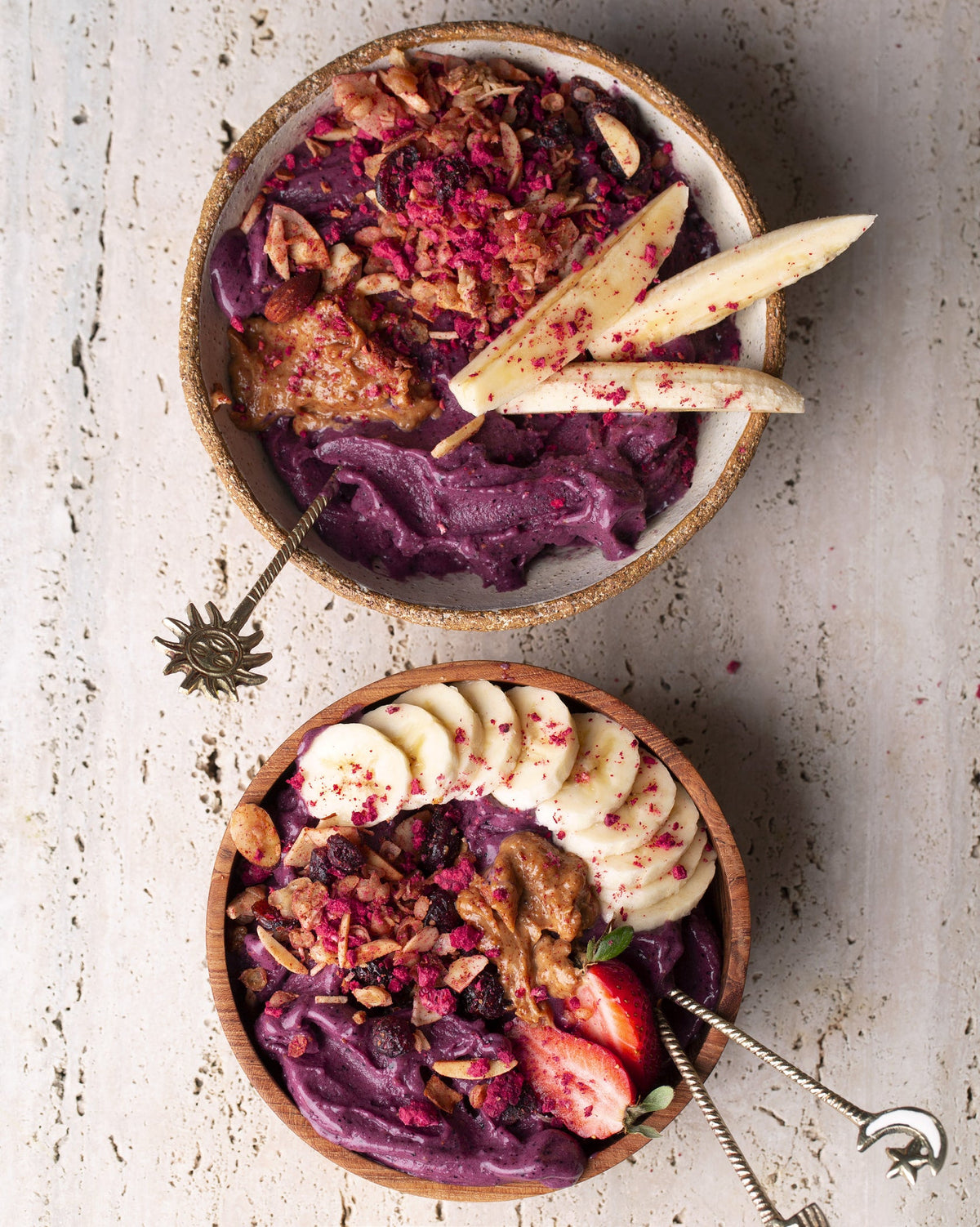 Two bowls filled with blueberry and banana smoothies, a Simple Wholefoods | 100 Effortlessly Delicious Plant Based Recipes for Everyday brand delight.