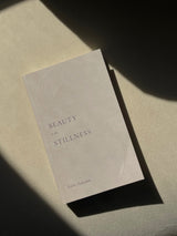 A book with the title "Beauty in the Stillness" sitting on a table. (Thought Catalog)