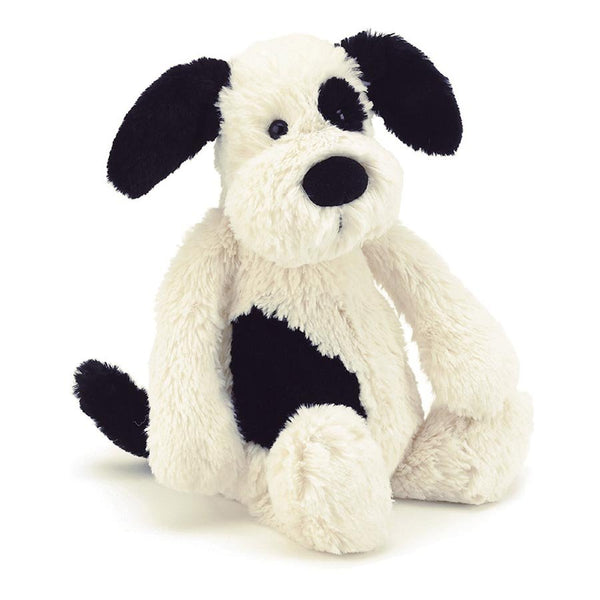A snuggly Bashful Black & Cream Puppy Small by Jellycat sitting against a soft white background.