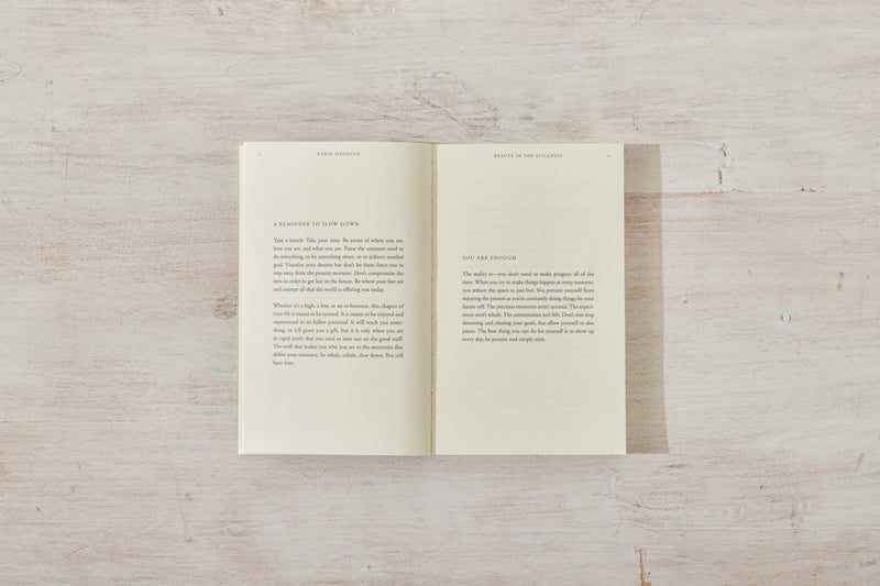 A "Beauty in the Stillness" book open on a wooden surface. (Thought Catalog)