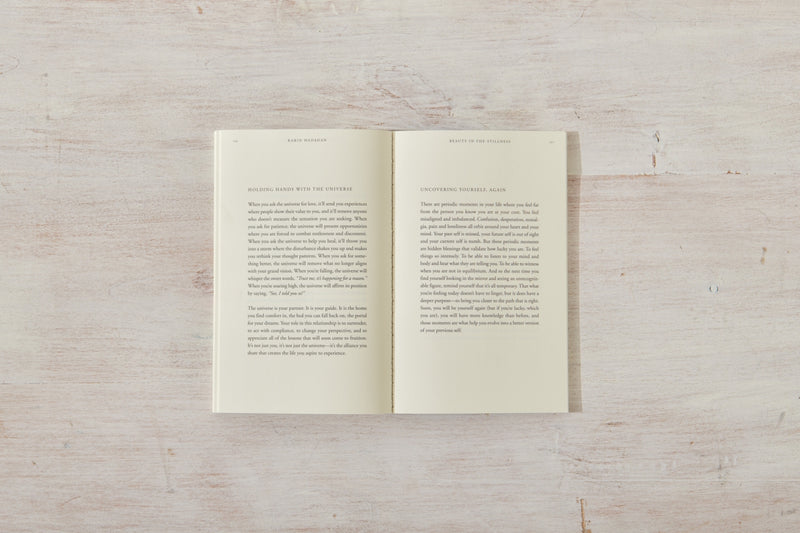 An open Beauty in the Stillness book on a wooden surface. (Thought Catalog)