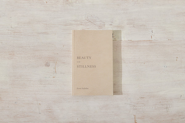 A "Beauty in the Stillness" book on a wooden surface with the words 'beauty and the beast'. (Brand: Thought Catalog)