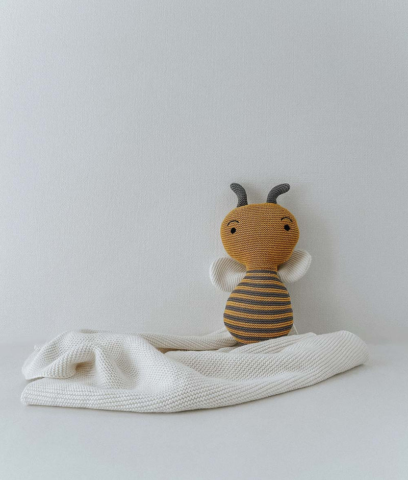 HONEYBEE SNUGGLY stuffed animal from Bengali Collections on a white blanket.