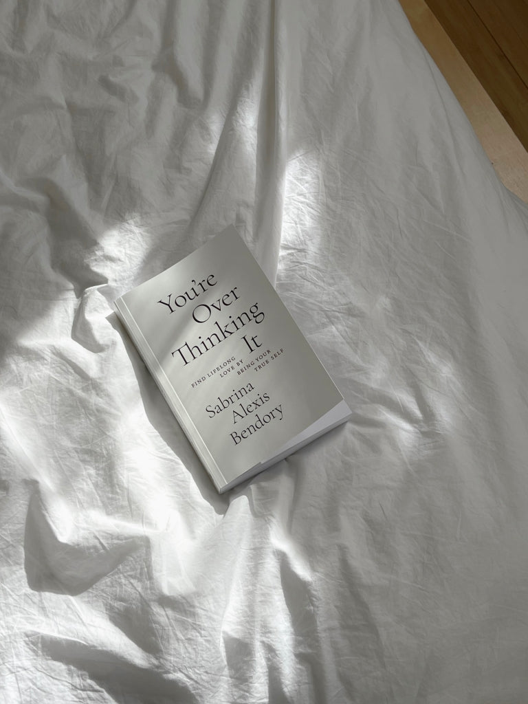 Book lying on white bedding